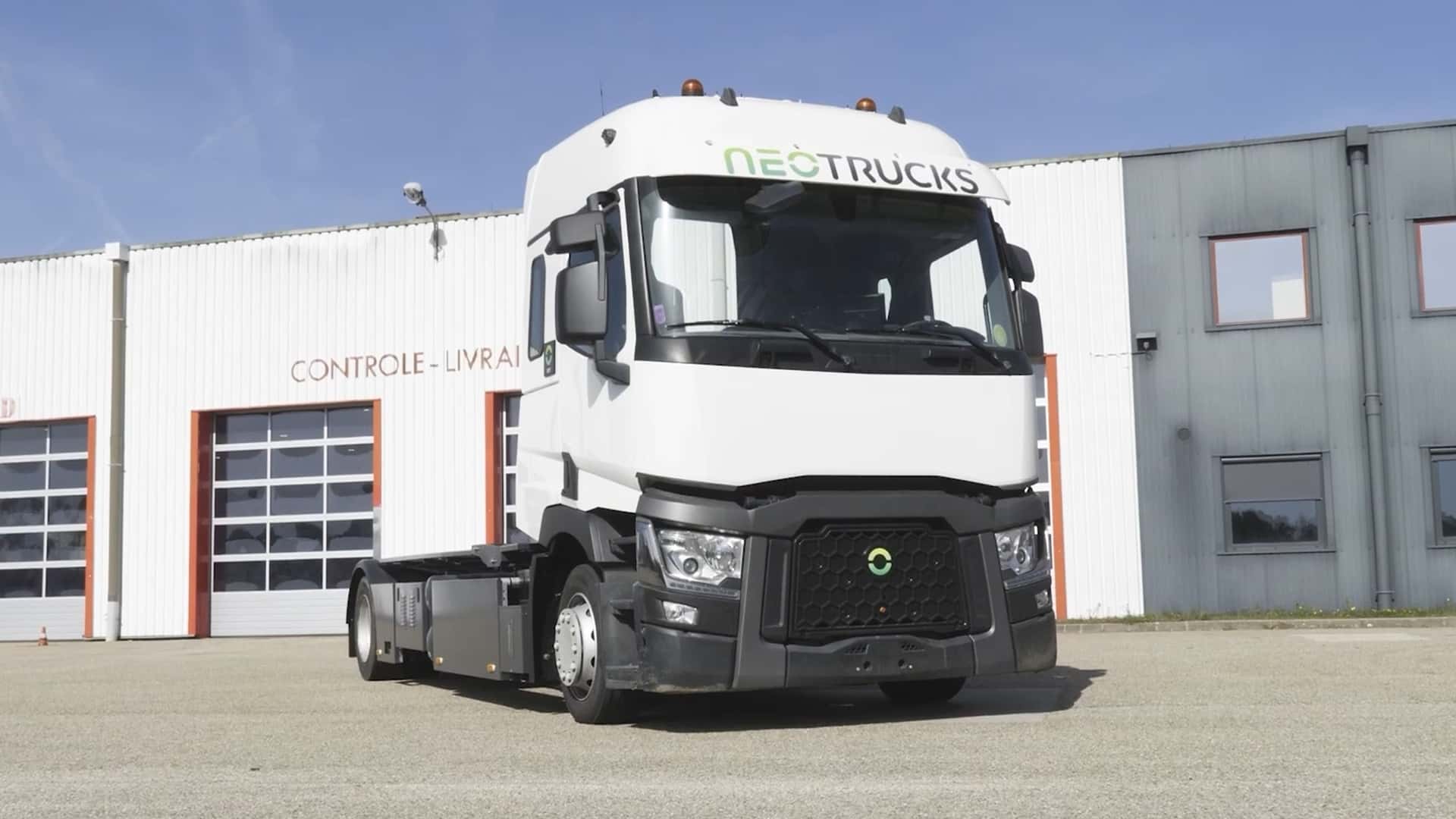 Hvid elektrisk lastbil fra Neotrucks foran industribygning