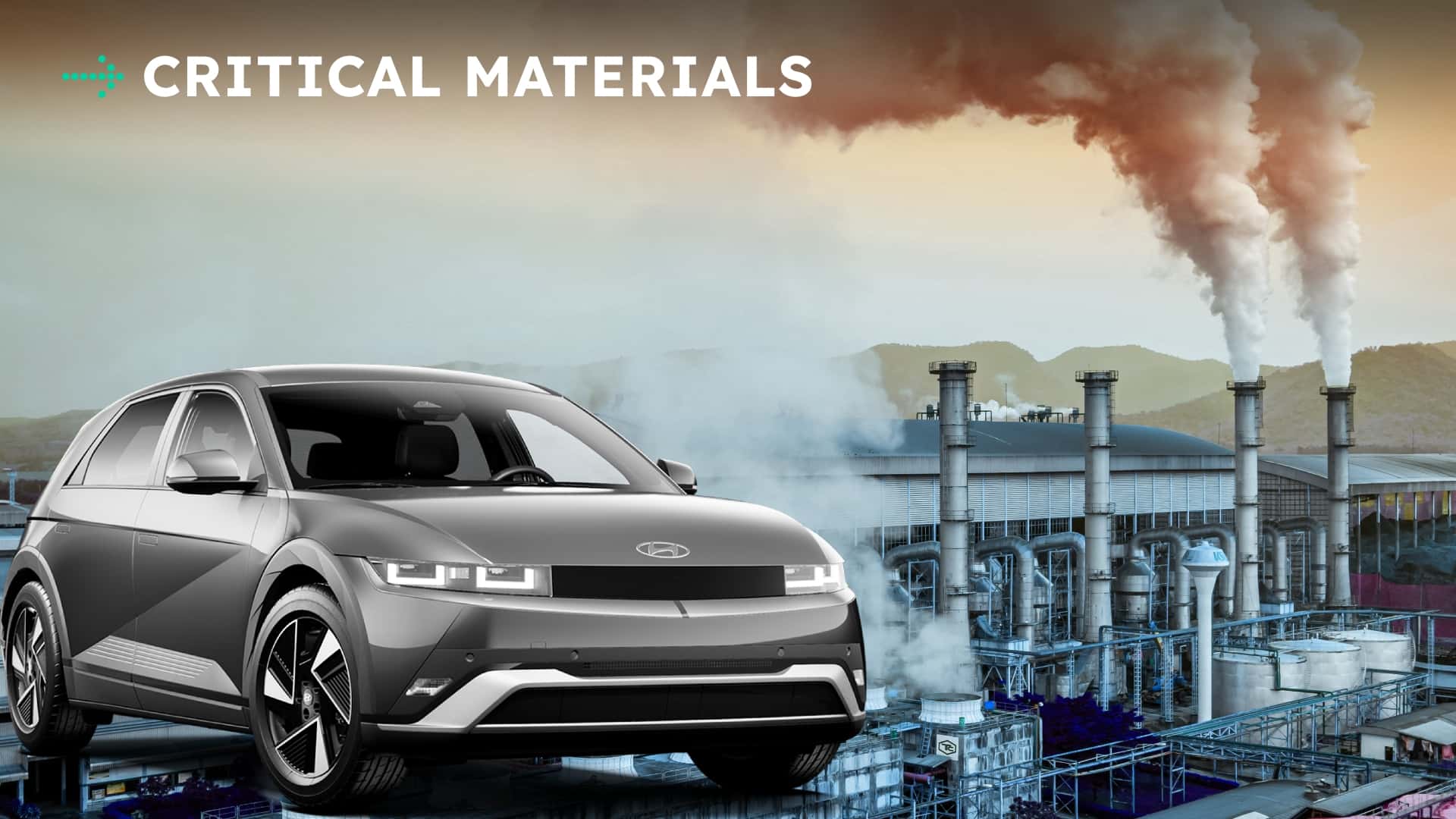 Elektrisk bil foran industriområde under overskyet himmel