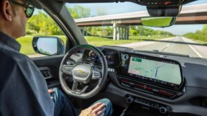 Fører i en Tesla med autopilot aktiv og moderne dashboard.
