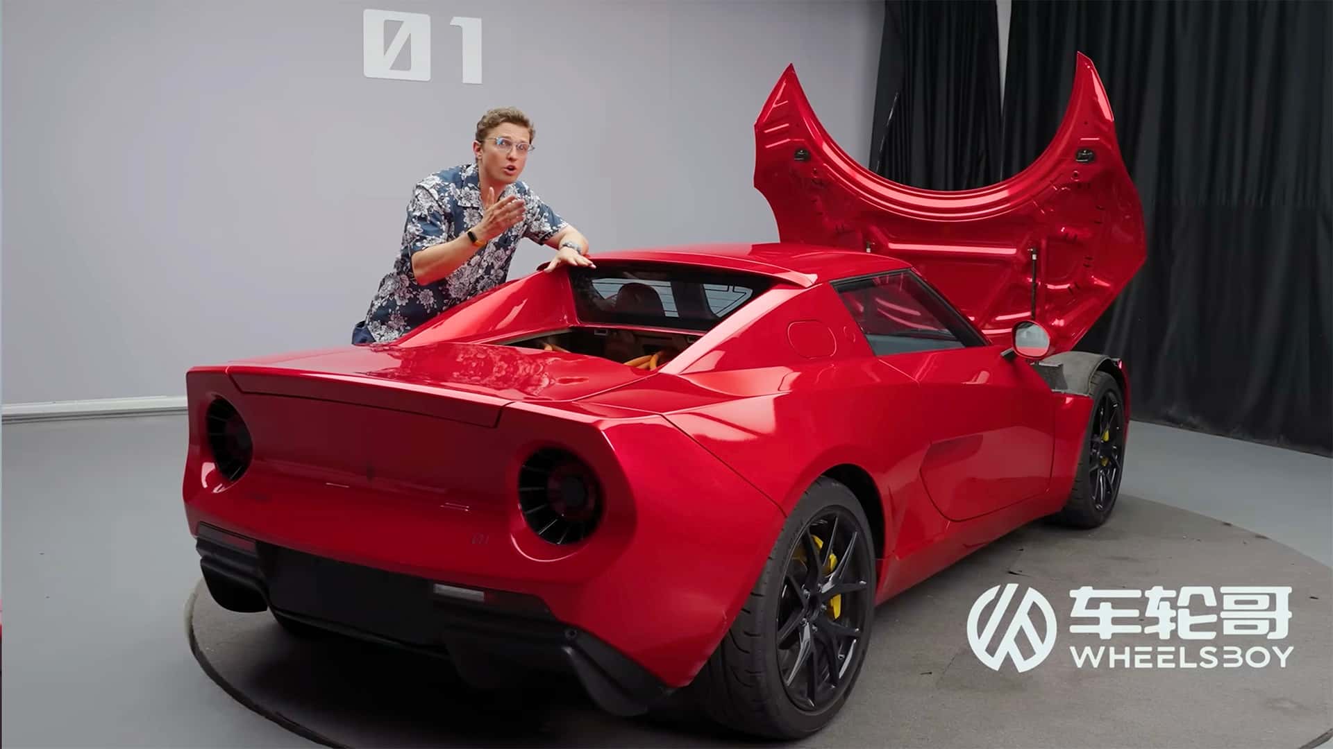 Mand ved siden af en rød sportselbil med bagagerummet åbent på en Tesla nyhedsblog