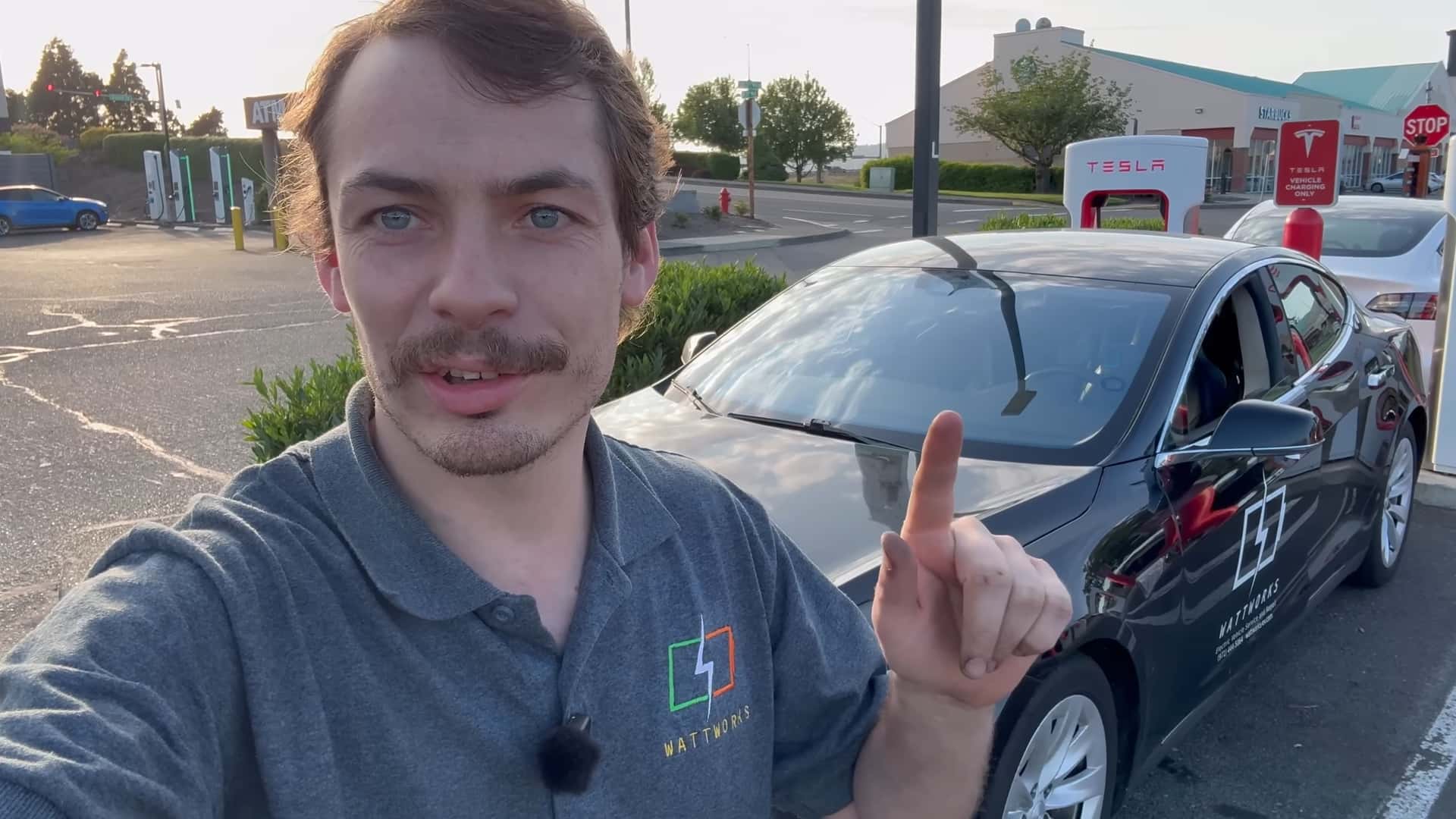 Mand foran en Tesla bil ved en ladestation