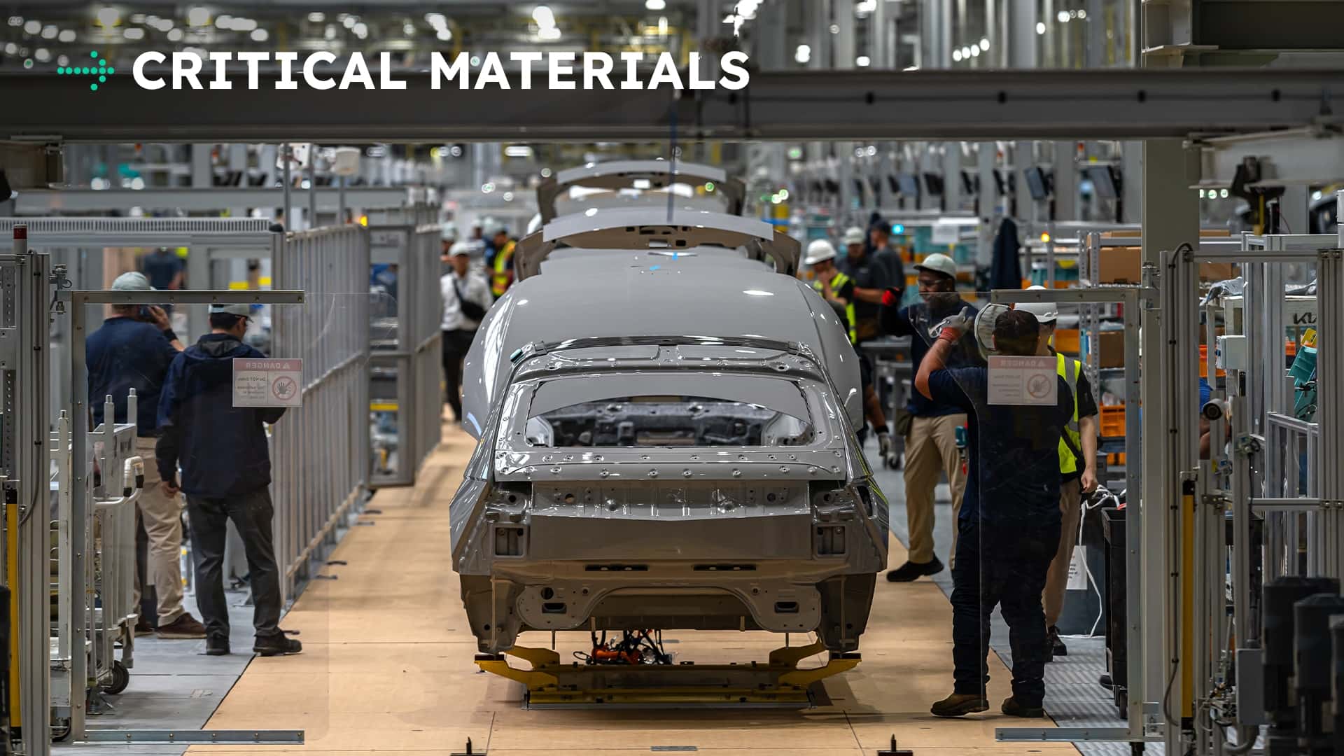 Tesla produktionslinje med arbejdstagere og biler under samling