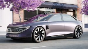 Futuristisk elbil parked under lilla træer foran en bygning