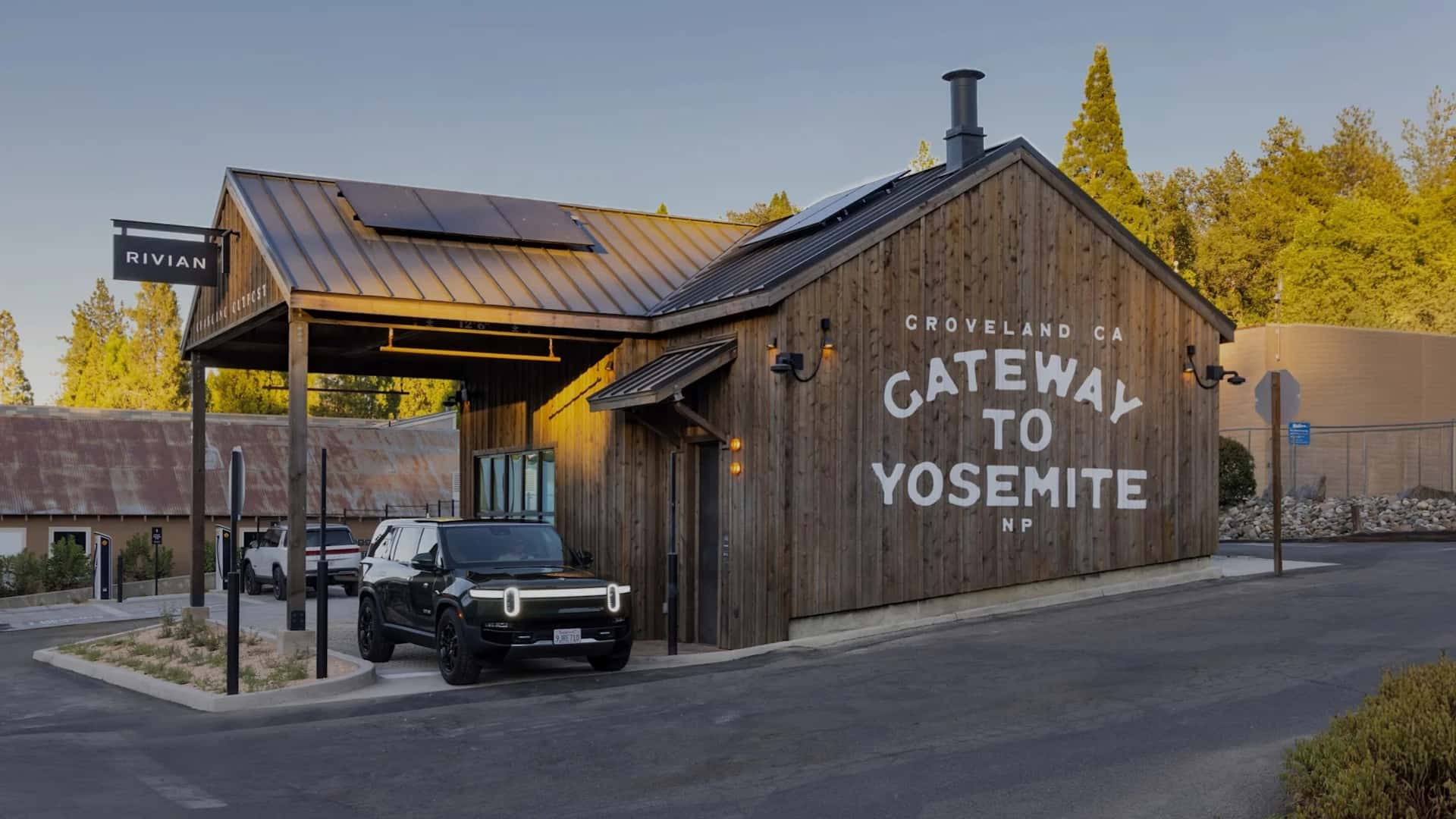 Rivian elbil parkeret ved en træbygning ved indgangen til Yosemite Nationalpark