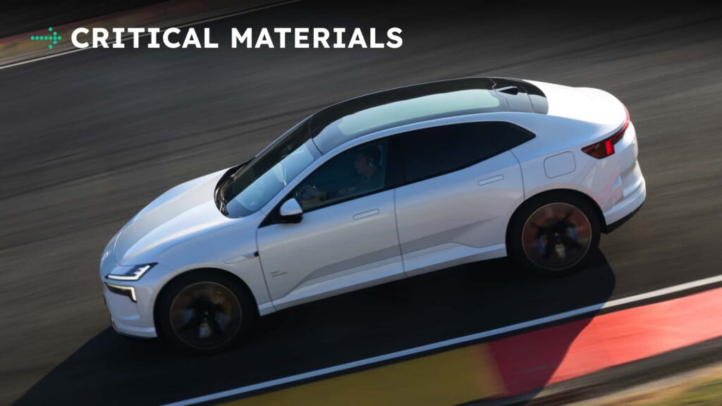 Hvid elektrisk bil kører hurtigt på racerbanen, med teksten 'CRITICAL MATERIALS' øverst