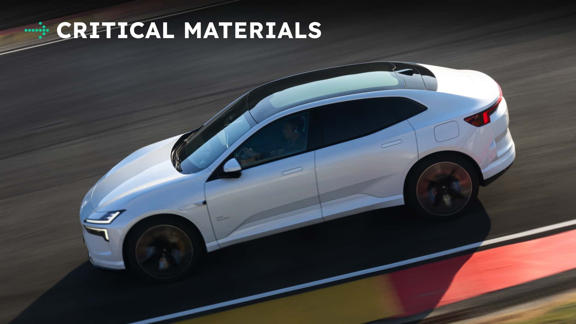 Hvid elektrisk bil kører hurtigt på racerbanen, med teksten 'CRITICAL MATERIALS' øverst