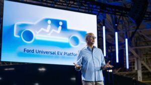 Person præsentation foran skærm med Ford Universal EV Platform illustration