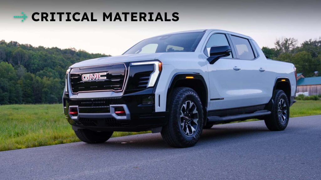 Hvid GMC pickuptruck parkeret på en vej med teksten 'CRITICAL MATERIALS' i baggrunden