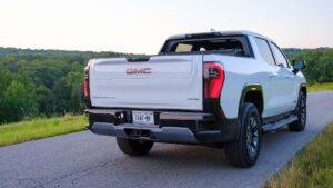 Hvid GMC pickup truck set bagfra på en naturskøn vej med skovudsigt