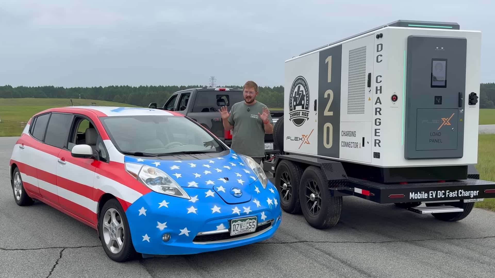 Bil dekoreret med amerikansk flag ved siden af mobil EV-hurtiglader FLEX X