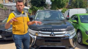 Person står ved siden af en Mitsubishi Outlander på parkeringsplads