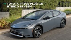Toyota Prius plug-in hybrid i grå farve set fra siden, parkeret ved vejsiden.