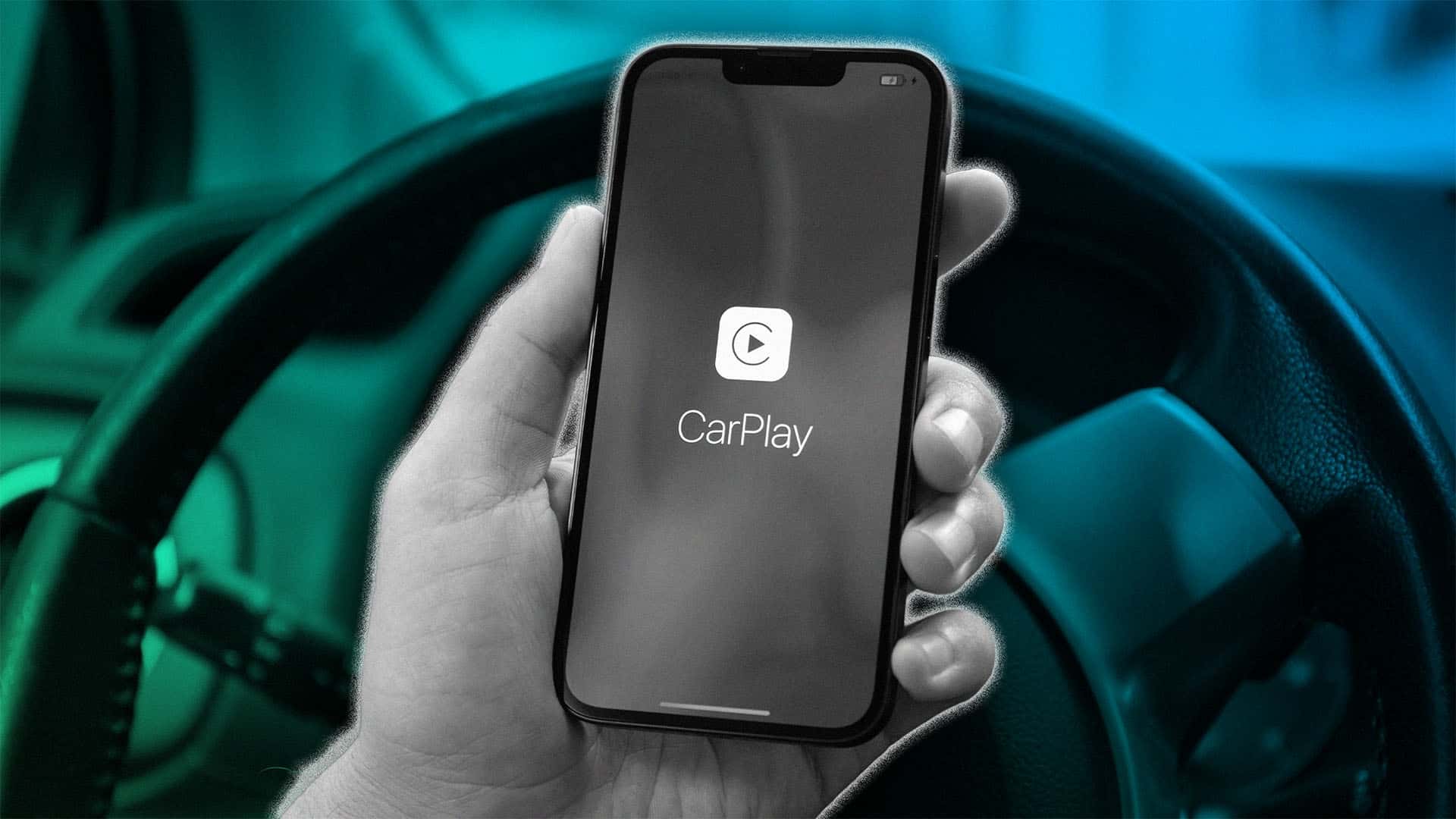 Hånd holder en smartphone med Apple CarPlay-skærm foran et bilrat