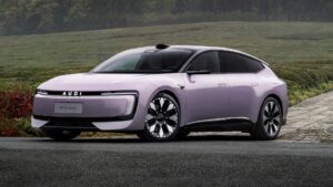 Audi E5 Sportback elbil i lilla parkeret på en sti med grønne marker i baggrunden