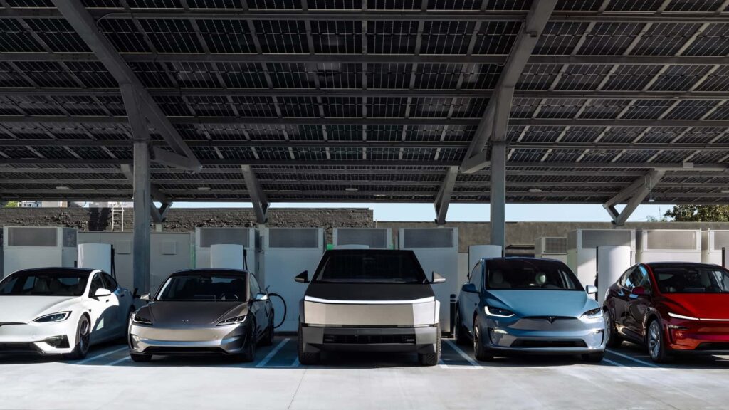Tesla-biler parkeret under solpaneler i et ladeområde