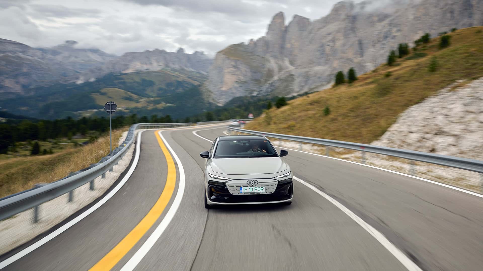 Elektrisk bil kører på snoede bjergveje i smukke landskaber