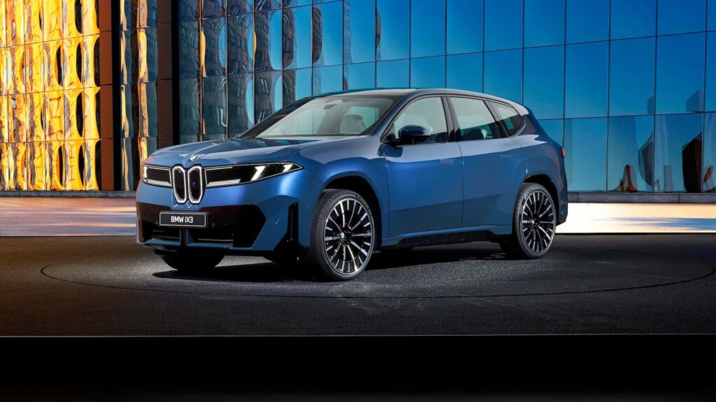 BMW iX3 i blå farve foran moderne bygning med reflekterende glasfacade