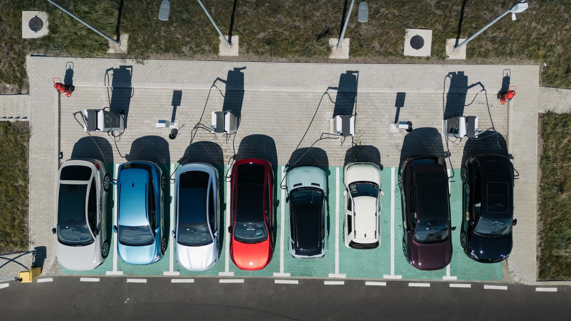 Luftfoto af flere electric biler parkeret ved en ladestation