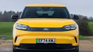 Forfra af gul Ford Capri elbil på en parkeringsplads