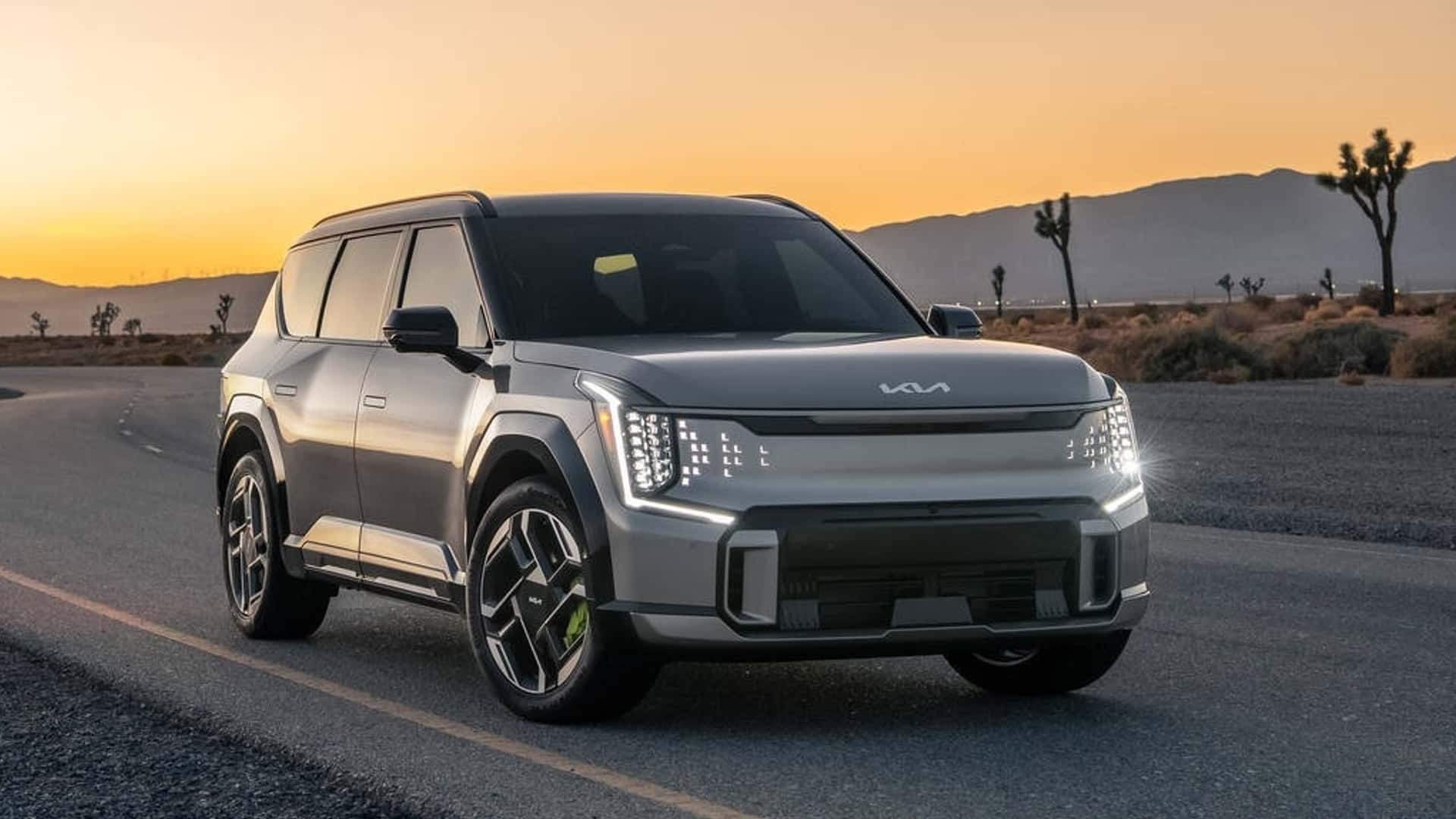 Elektrisk SUV på landevej ved solnedgang