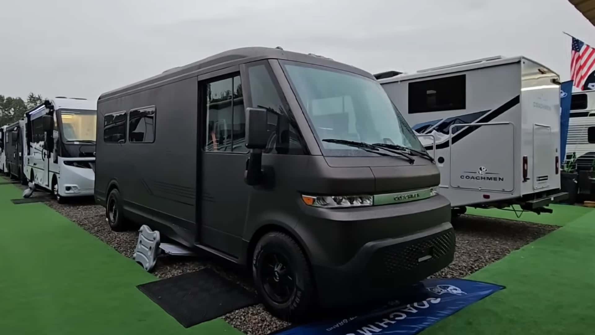 Elektrisk campervan i udstillingsområde omringet af andre campingvogne