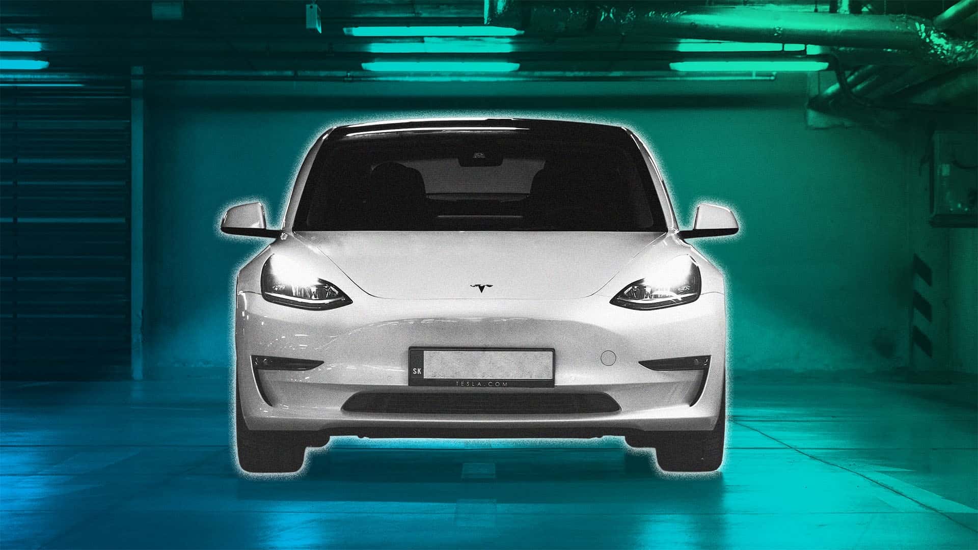 Fronten af en hvid Tesla i en moderne parkeringskælder