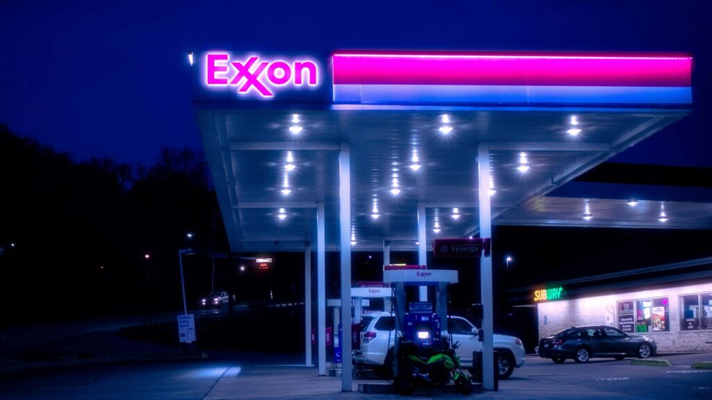 Exxon tankstation oplyst om natten med biler parkeret ved pumperne