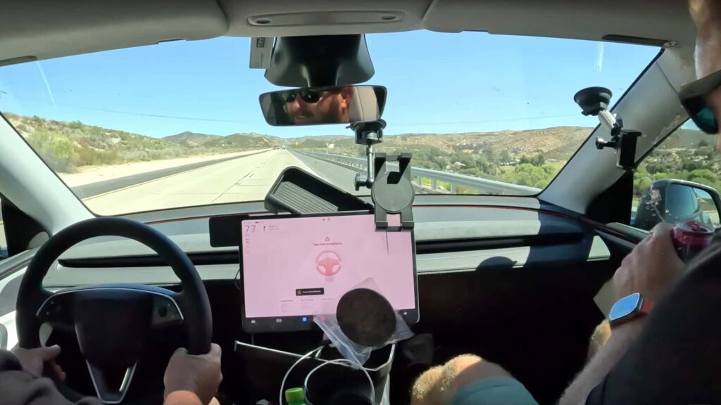Indvendigt syn af Tesla-kabine med autopilot aktiveret på åben vej