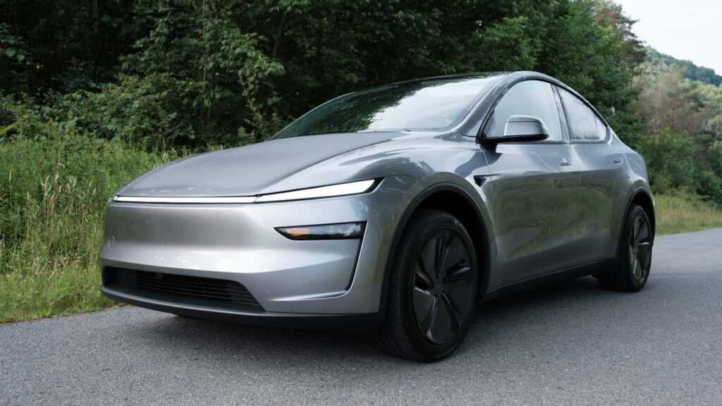 Sølvfarvet elektrisk bil parkeret på en skovvej