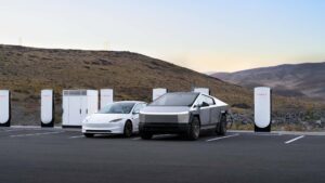 Tesla Model 3 og Cybertruck lader ved Tesla Supercharger-station i ørkenlandskab
