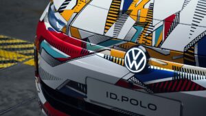 Nærbillede af en bil med farverigt, geometrisk mønster på kølergrillen og Volkswagen-logoet