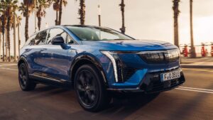 Elektrisk blå SUV kører på vej med palmer i baggrunden