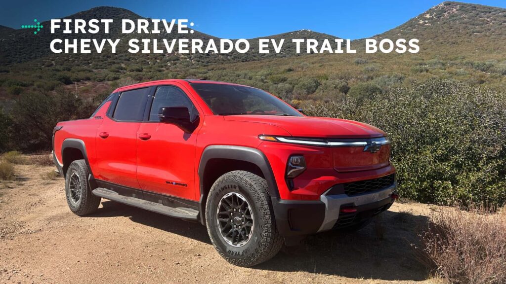 Rød Chevy Silverado EV Trail Boss på en grusvej foran bjerge