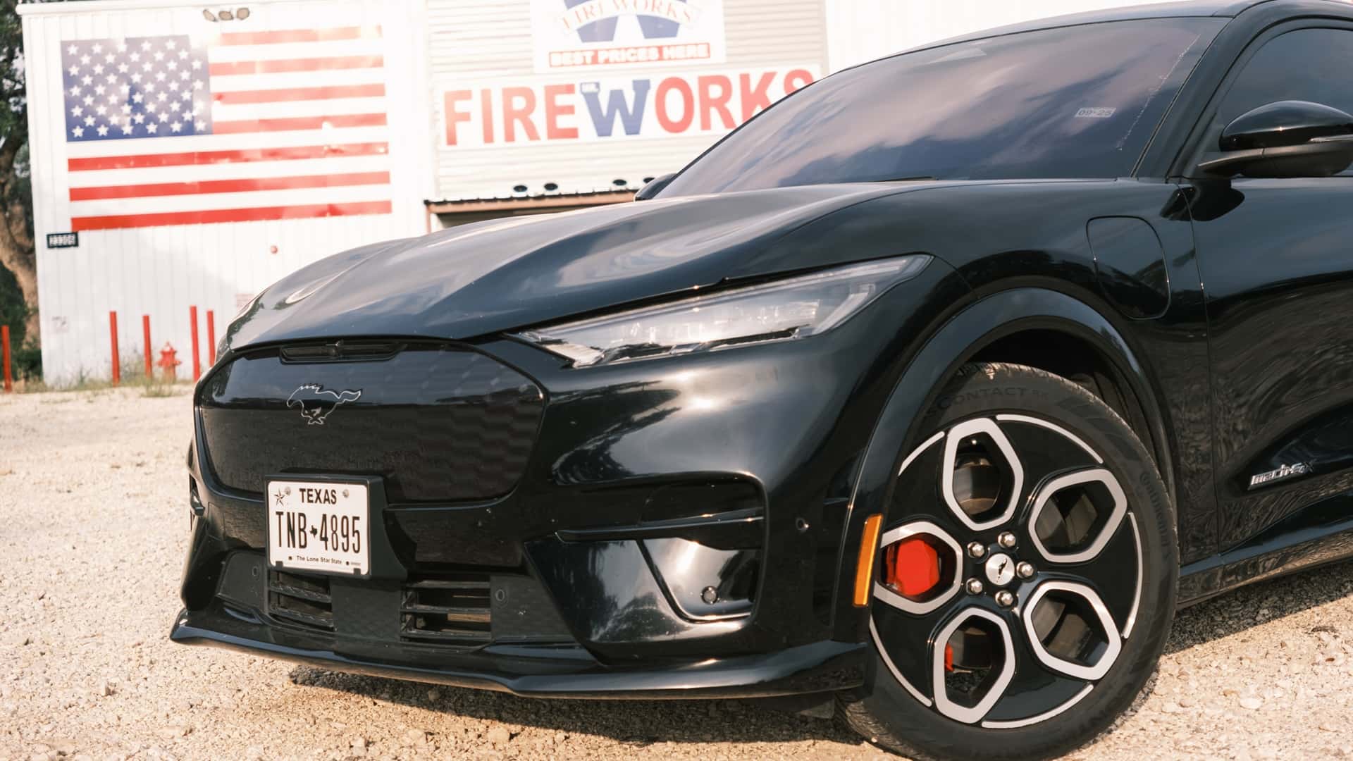 Sort elektrisk bil med moderne design foran en bygning med amerikansk flagmønster