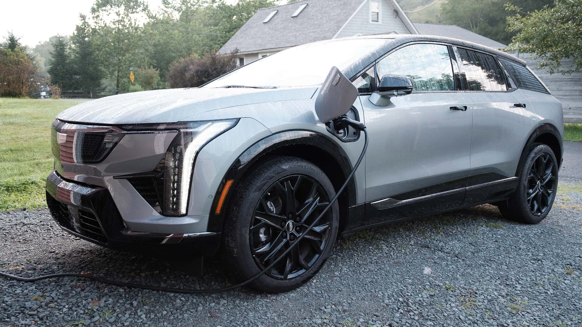 Elektrisk SUV oplades i en indkørsel med dug på karrosseriet