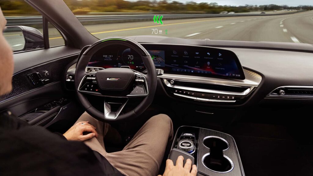 Person kører en moderne bil med digitalt display og avancerede funktioner.