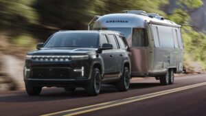 Elektrisk SUV trækker en Airstream campingvogn på en naturskøn vej