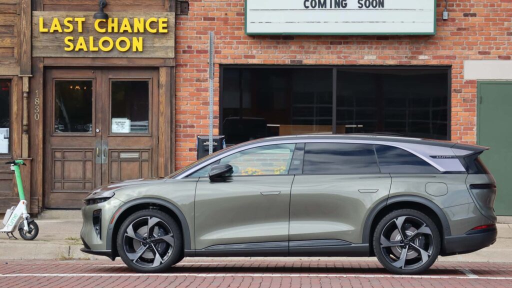 Elektrisk bil parkeret foran Last Chance Saloon med løbehjul på fortovet