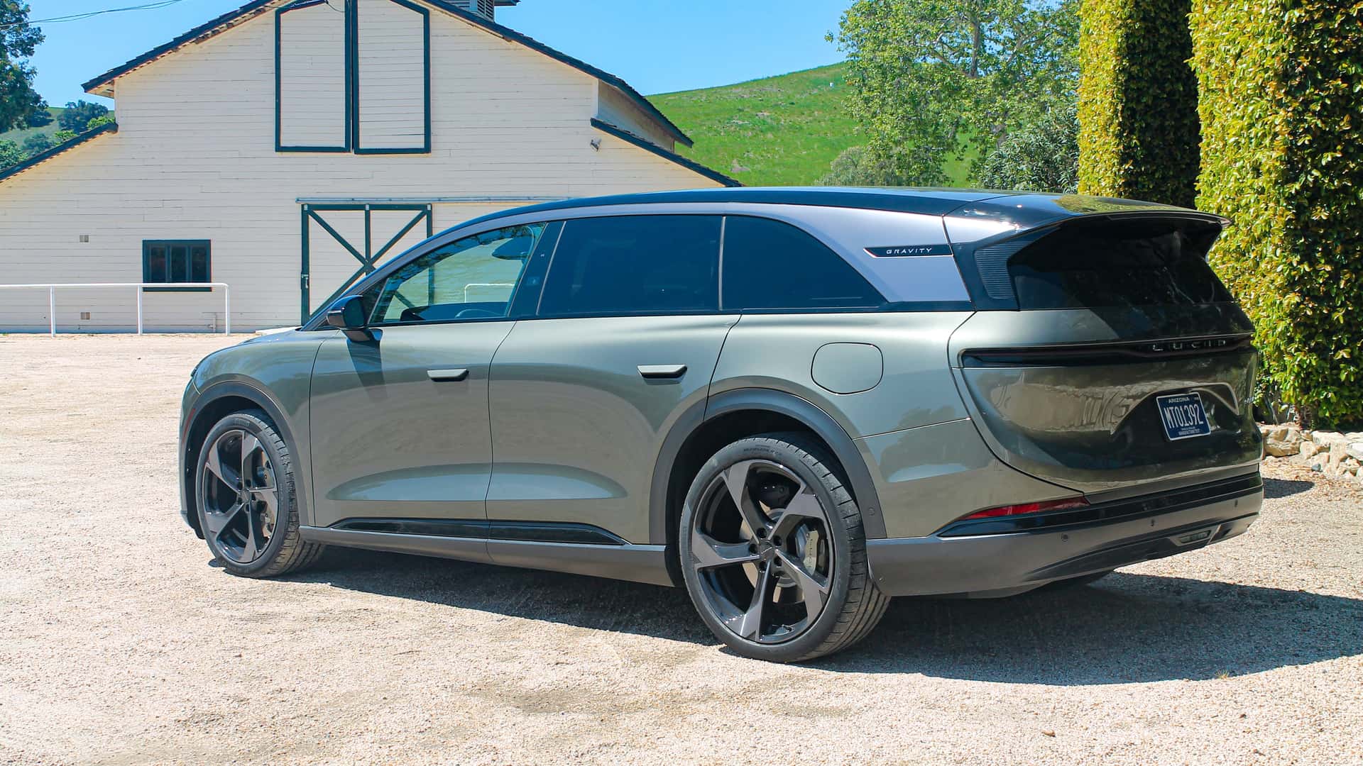 Elektrisk SUV parkeret foran en lade på en solrig dag