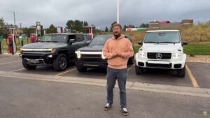 Mand står foran tre elektriske SUV'er på en ladestation.