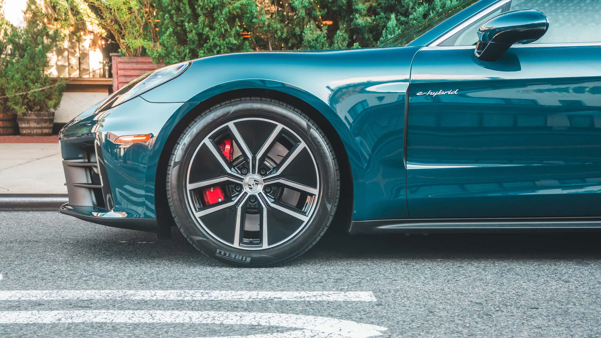 Nærbillede af en elektrisk bils side og hjul med moderne design på en byvej