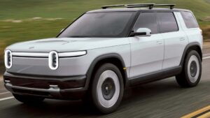 Moderne elektrisk SUV kører på en vej med grønne bakker i baggrunden