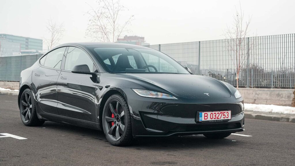 Sort Tesla elbil parkeret udendørs, set fra fronten.