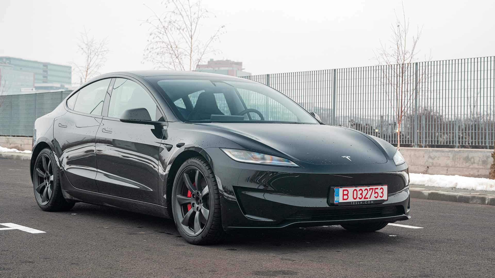 Sort Tesla elbil parkeret udendørs, set fra fronten.