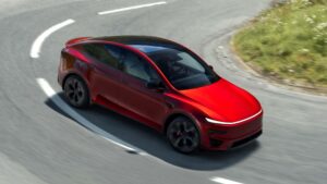 Rød Tesla elbil på en snoet vej set fra oven.