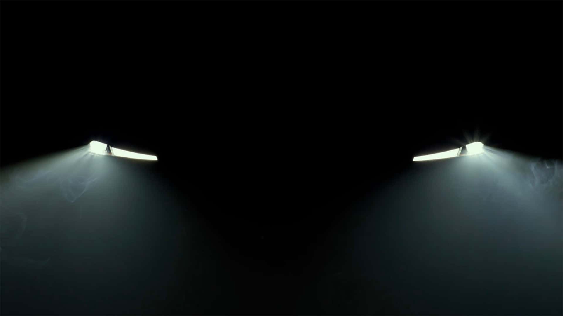 Tæt på forlygter af en Tesla bil i mørke