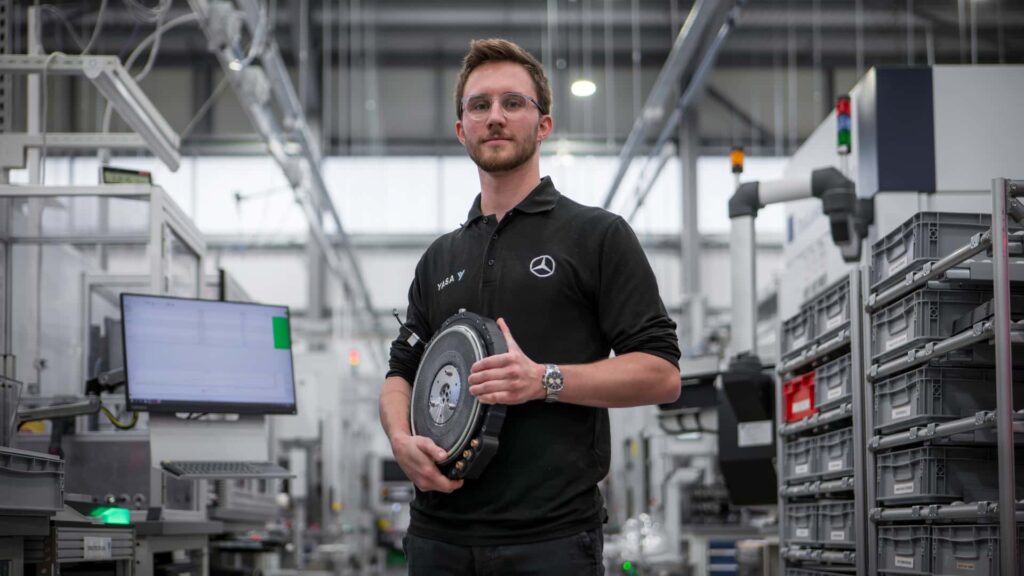 Mand med elektrisk motor i moderne bilproduktionsanlæg