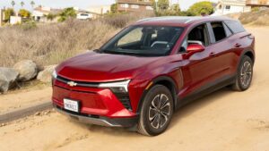 Rød elektrisk SUV kører på en grusvej i et boligområde