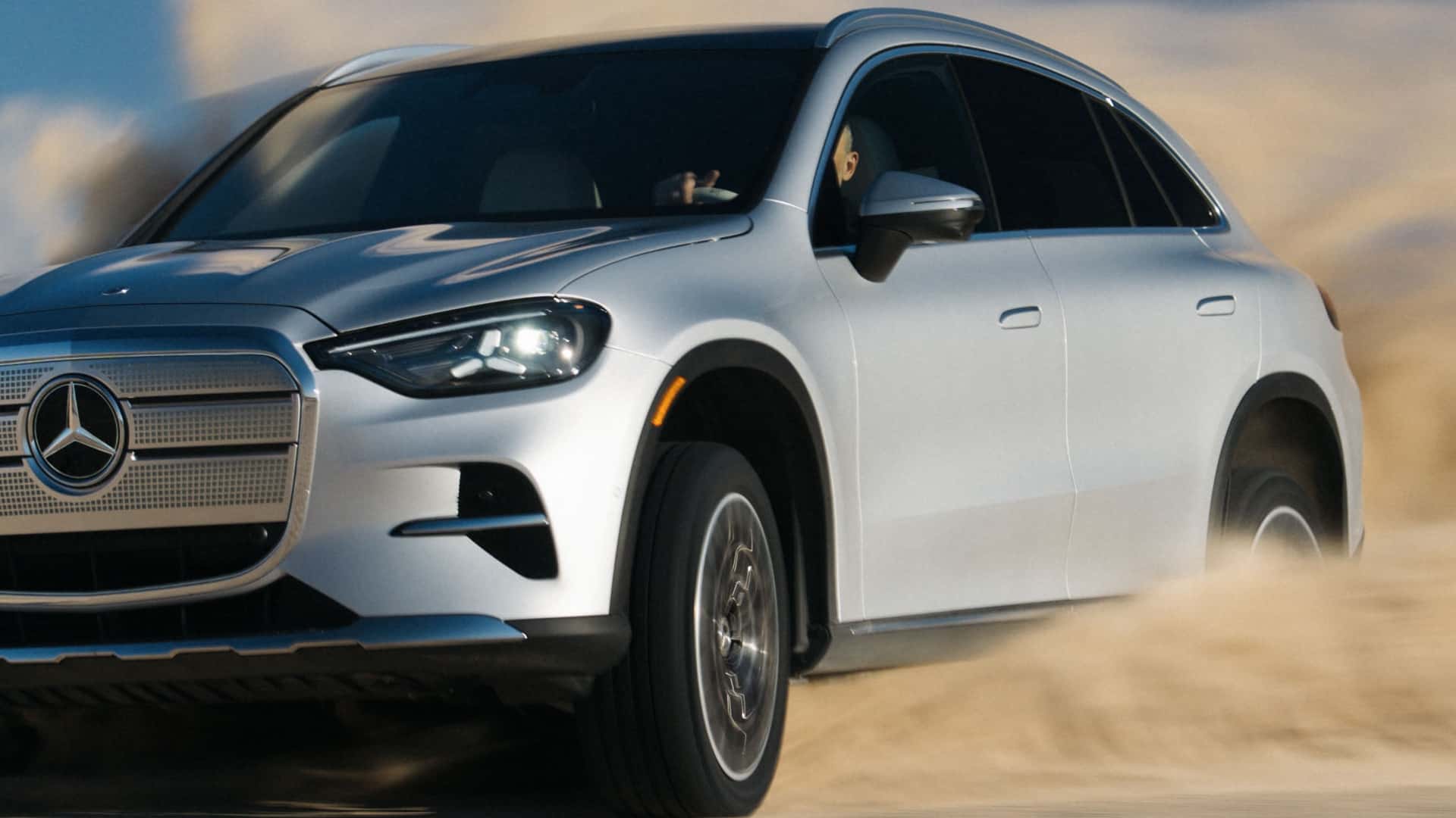 Elbil kører gennem sand i høj fart