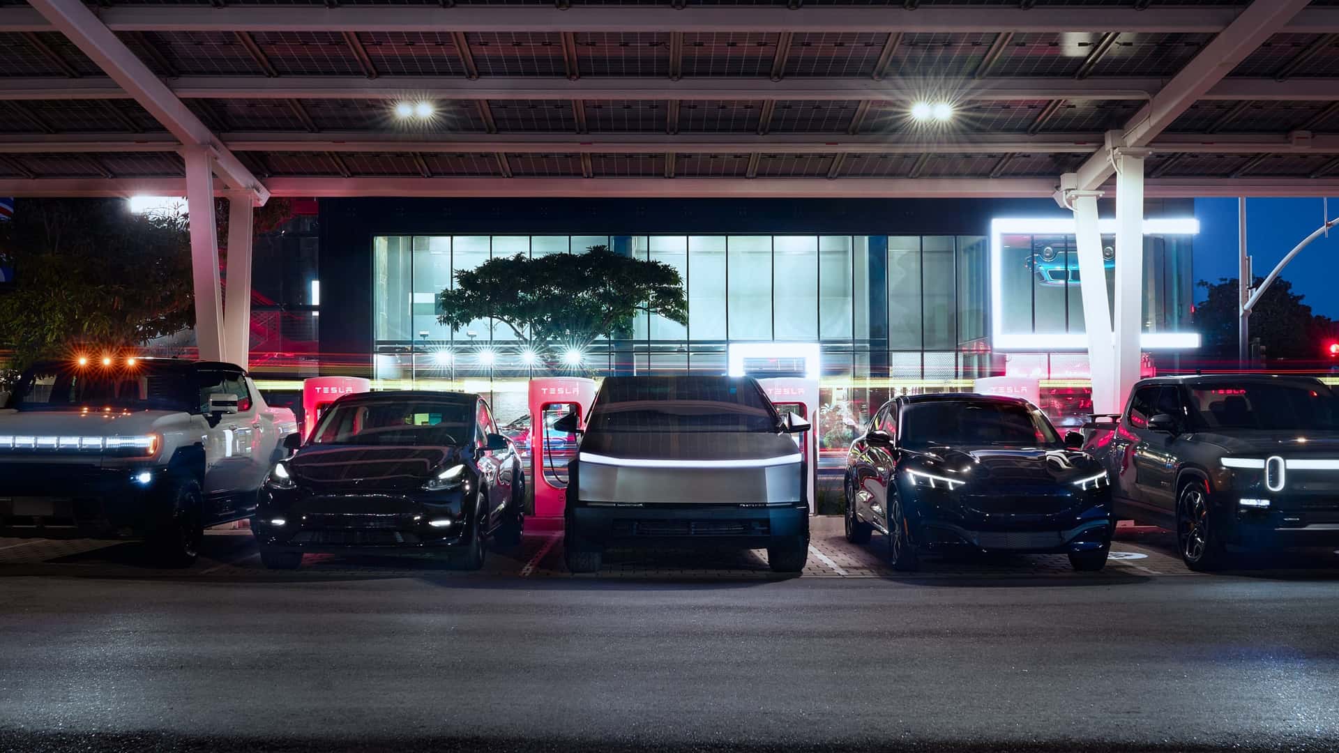 Tesla biler ved en ladestation om natten under overdækning